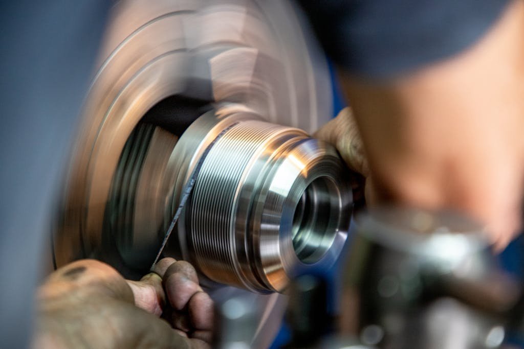 Close-up view of a worker grinding metal, showcasing precision and craftsmanship in industrial setting.